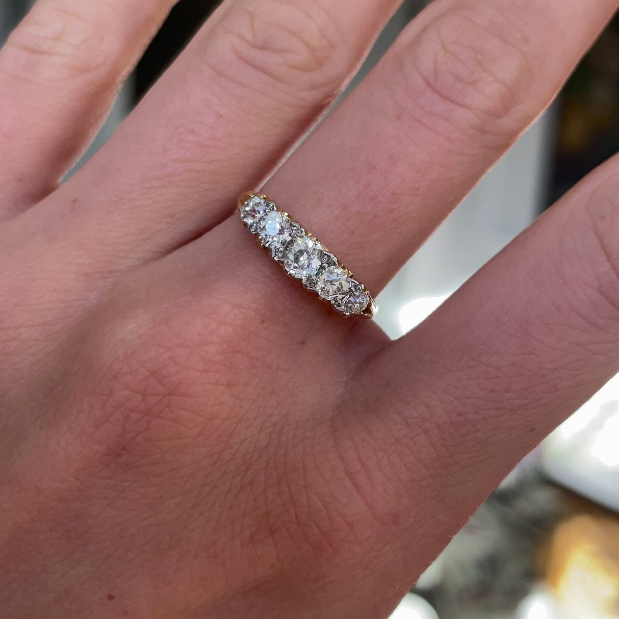 Victorian five stone diamond engagement ring, worn on hand and rotated to give perspective.