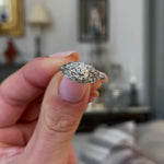Art Deco diamond engagement ring, held in fingers and rotated to give perspective.