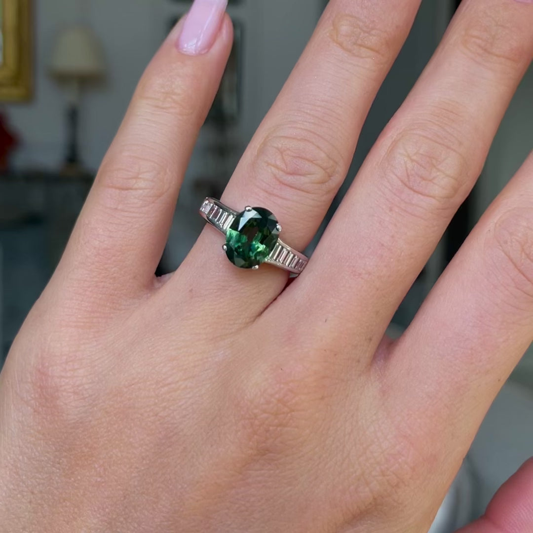 Green sapphire and diamond engagement ring worn on hand and moved around to give perspective. 
