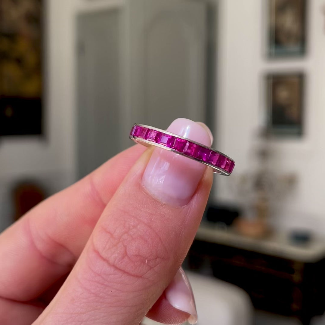 Pink sapphire eternity ring, held in fingers and moved around to give perspective.