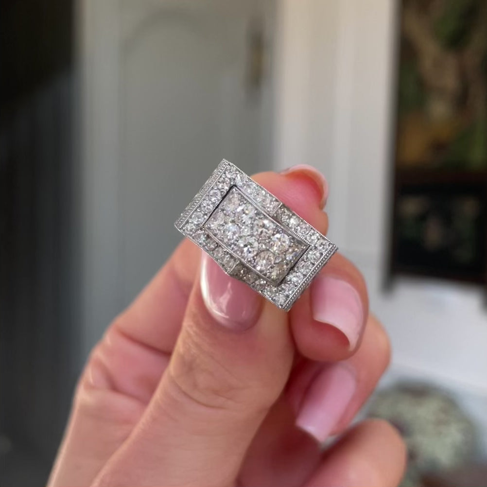 Art Deco diamond filligree band, held in fingers and rotated to give perspective.