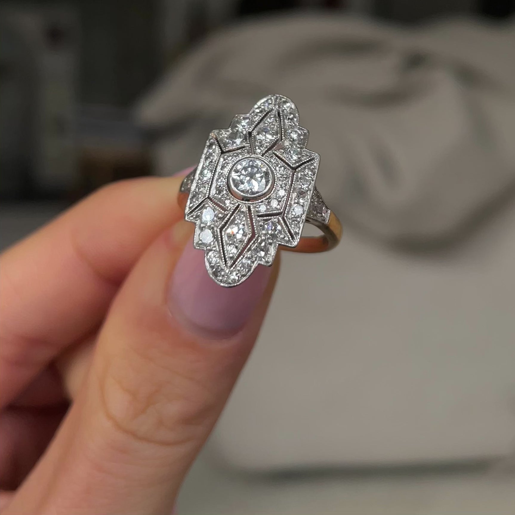 Art Deco diamond navette engagement ring, held in fingers and rotated to give perspective.