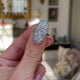 Victorian diamond panel navette ring, held in fingers and rotated to give perspective.