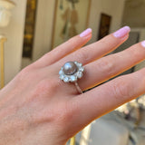 Antique natural pearl and diamond ring, worn on hand.