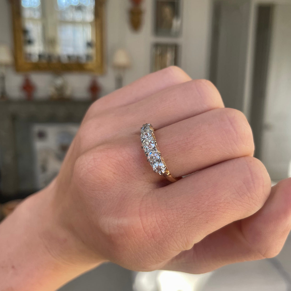 Victorian five-stone diamond engagement ring, worn on hand.