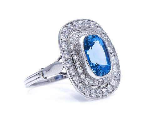 Edwardian, platinum, natural ‘cornflower’ ceylon sapphire and double row diamond cluster ring