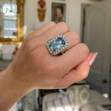 Art Deco aquamarine and diamond cluster ring, worn on hand.