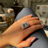 Art Deco aquamarine and diamond cluster ring, worn on hand.