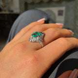 Art Deco emerald and diamond ring, worn on hand.