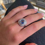 Art Deco, ceylon cushion-cut sapphire and diamond cluster ring, worn on hand on leg on jeans.