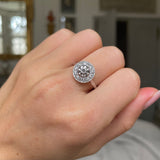Art Deco diamond cluster engagement ring, worn on hand.