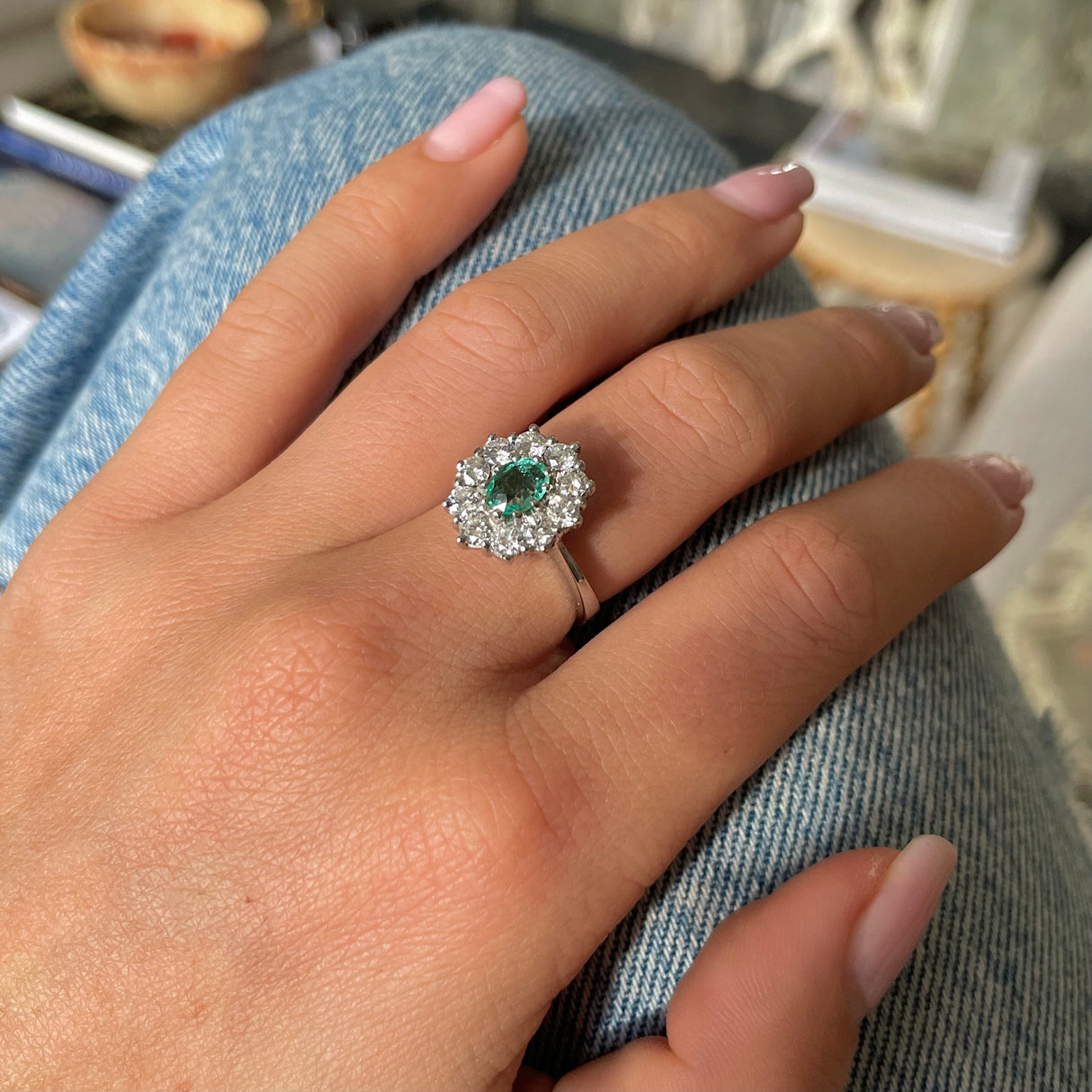 Austrian emerald and diamond cluster engagement ring, worn on hand.