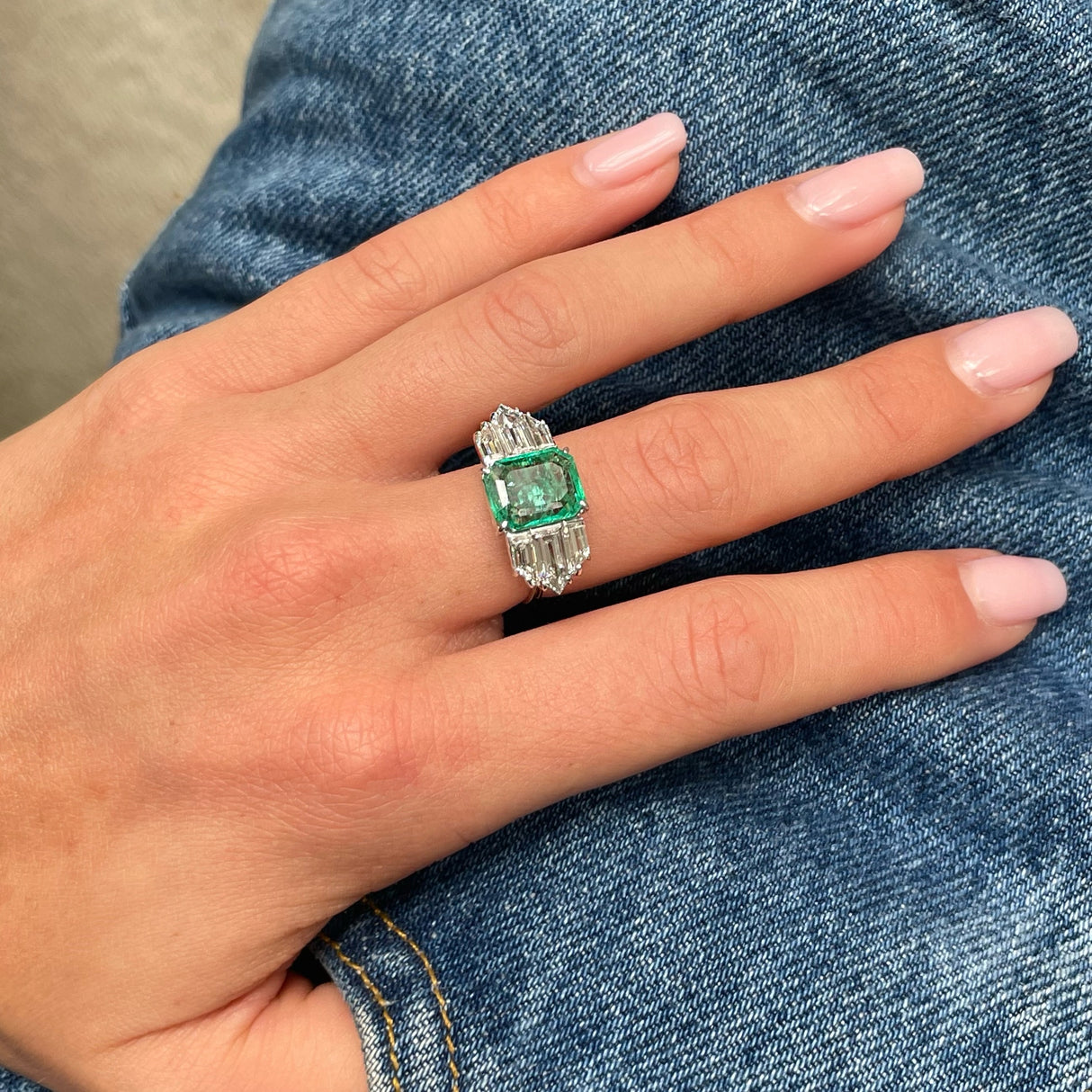 Vintage emerald and diamond engagement ring, worn on hand. 