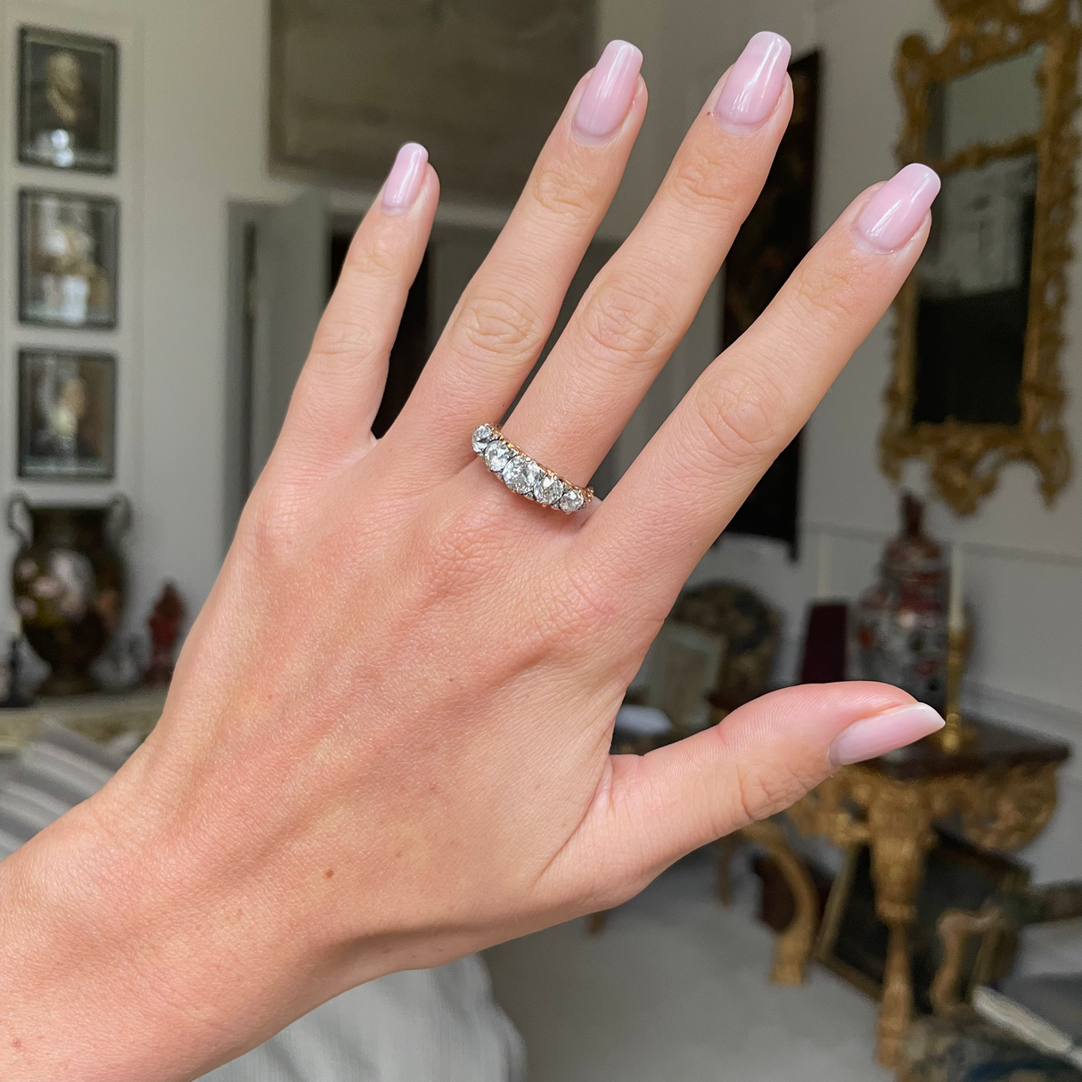 Victorian half-hoop diamond engagement ring, worn on hand. 