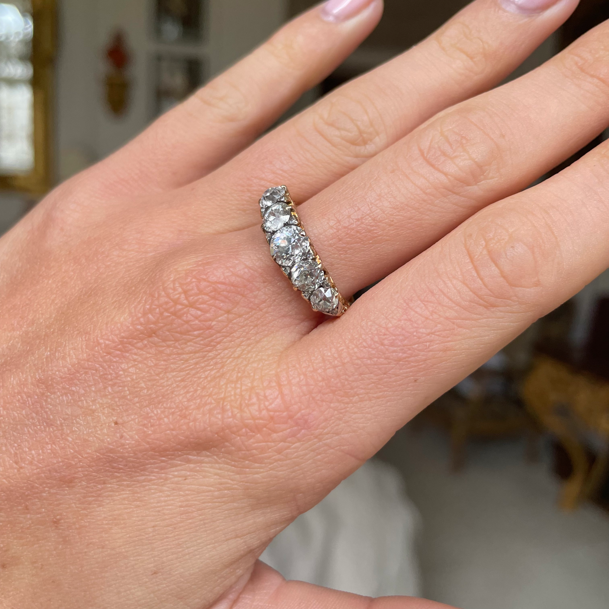 Victorian half-hoop diamond engagement ring, worn on hand.