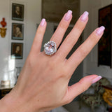 Morganite and diamond cluster cocktail ring, worn on hand.