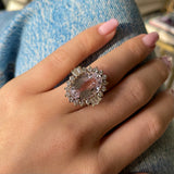 Morganite and diamond cluster cocktail ring, worn on hand.