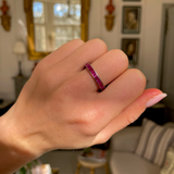 Pink sapphire eternity ring, worn on hand.