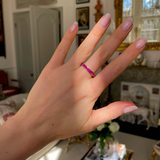 Pink sapphire eternity ring, worn on hand.