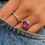 Pink sapphire and diamond engagement ring, worn on hand in pocket of jeans.