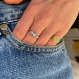 Antique Edwardian three-stone diamond engagement ring, worn on hand.