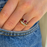 Victorian three-stone ruby and diamond engagement ring, worn on hand.