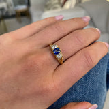 Sapphire and diamond three stone ring,  worn on hand. 