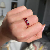 Victorian three-stone ruby and diamond engagement ring, worn on hand.