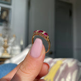 Victorian three-stone ruby and diamond engagement ring, held in fingers.