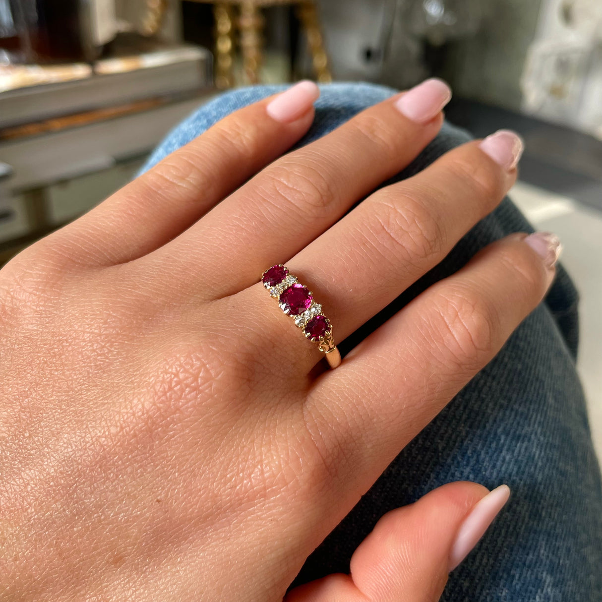 Victorian three-stone ruby and diamond engagement ring, worn on hand.