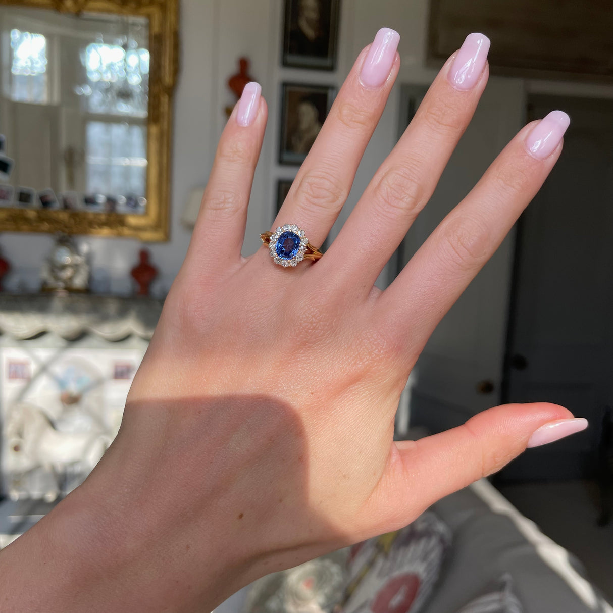 Victorian, sapphire and diamond cluster engagement ring, worn on hand.
