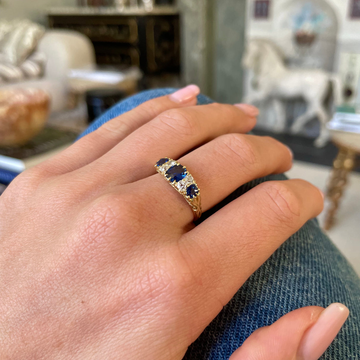 sapphire and diamond engagement ring, worn on hand.