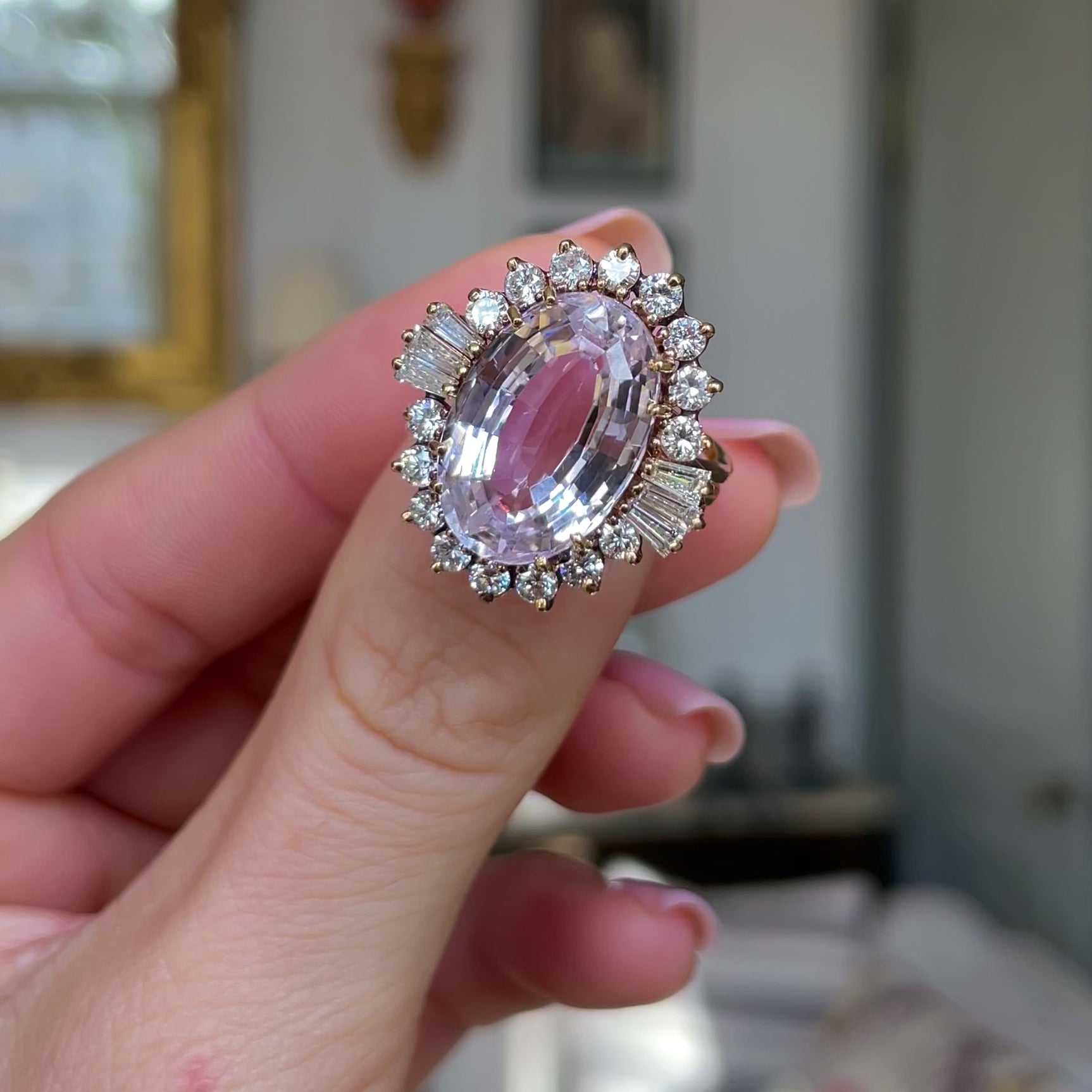 Morganite and diamond cluster cocktail ring, held in fingers and moved around to give perspctive 
