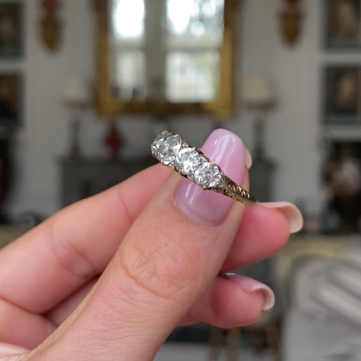 Victorian half-hoop diamond engagement ring, held in fingers and rotated to give perspective.