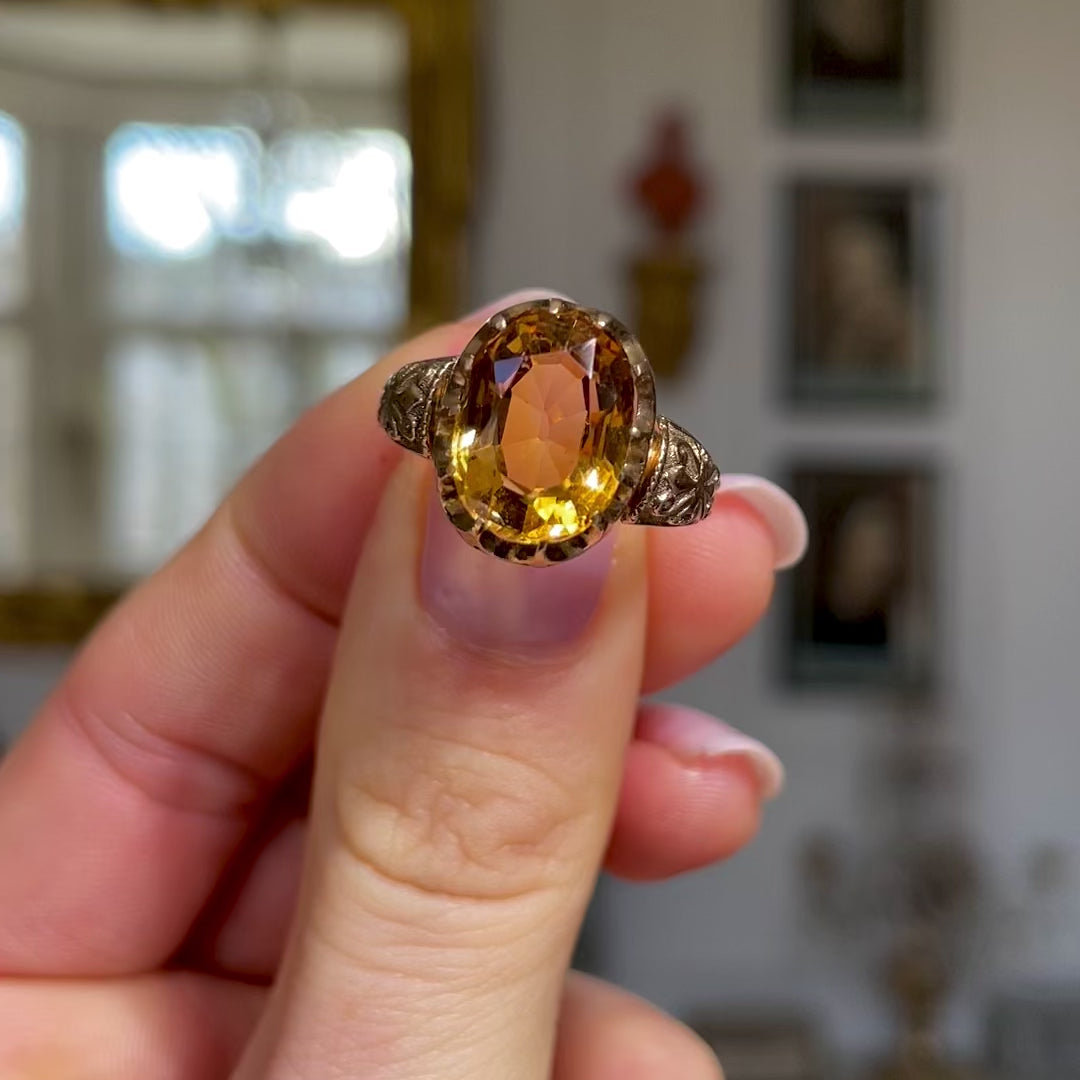 Imperial topaz single stone ring, held in fingers and moved around to give perspective.