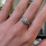 Art Deco diamond engagement ring, worn on hand and rotated to give perspecitve.